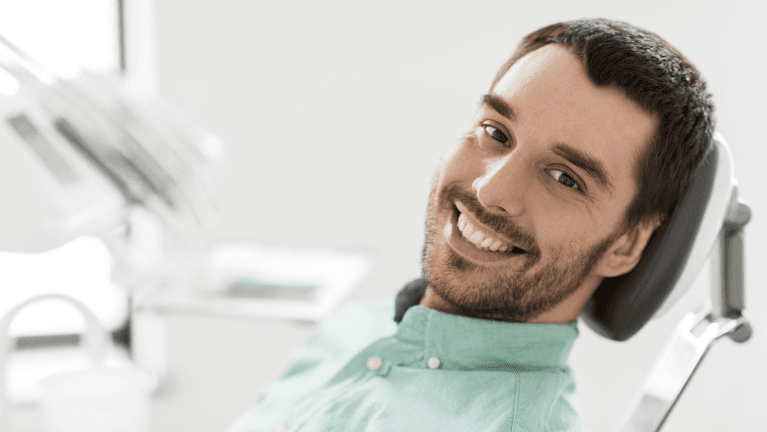 man sitting in a dental chair in raleigh nc