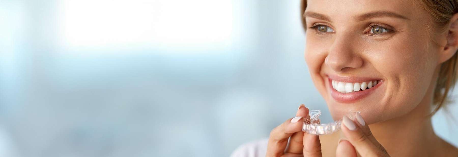 girl putting on her invisalign in raleigh nc